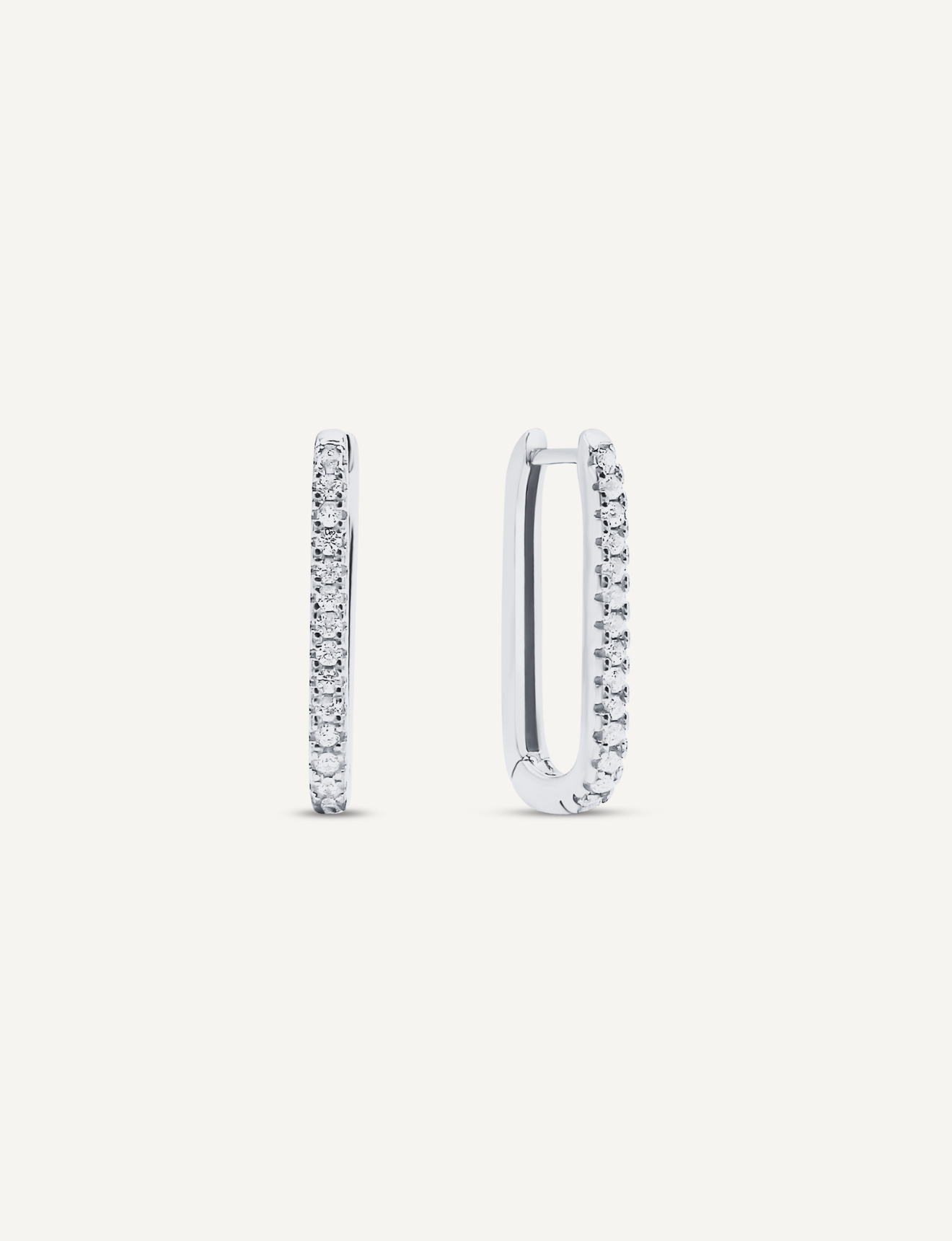 925 Sterling Silver oval shaped hoops that click close with a latch and are studded with small, round clear Cubic Zirconia crystals.